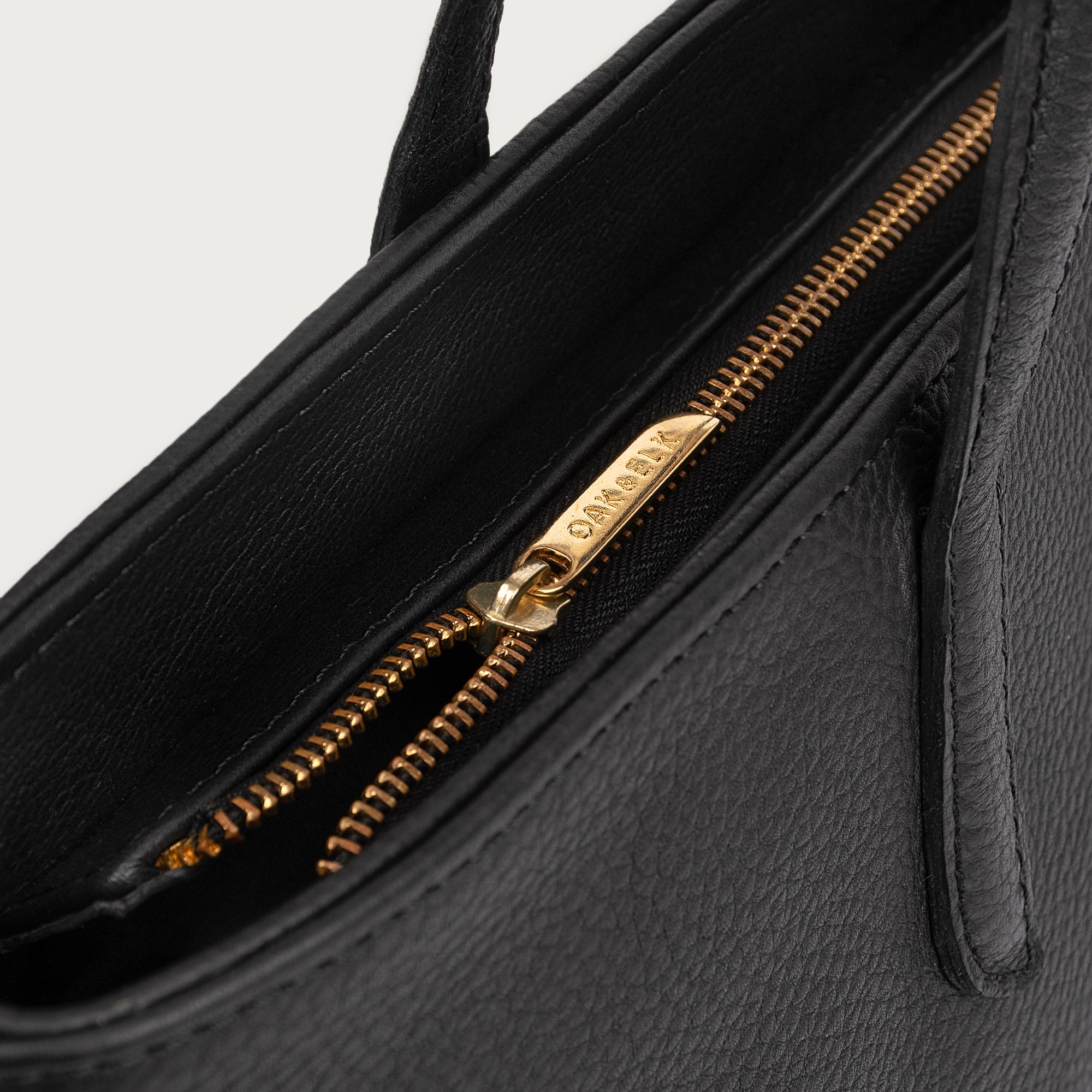 Leather tote made from top-grain leather, featuring smooth golden zipper, inner pouch, and structured design for daily use.