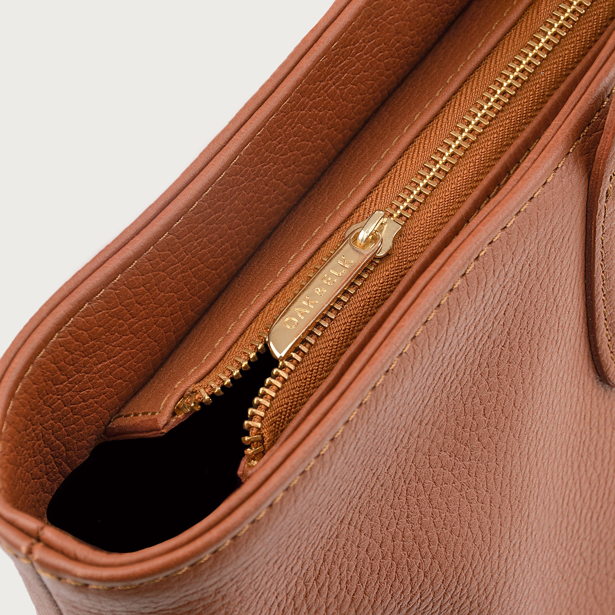 Leather tote made from top-grain leather, featuring smooth golden zipper, inner pouch, and structured design for daily use.