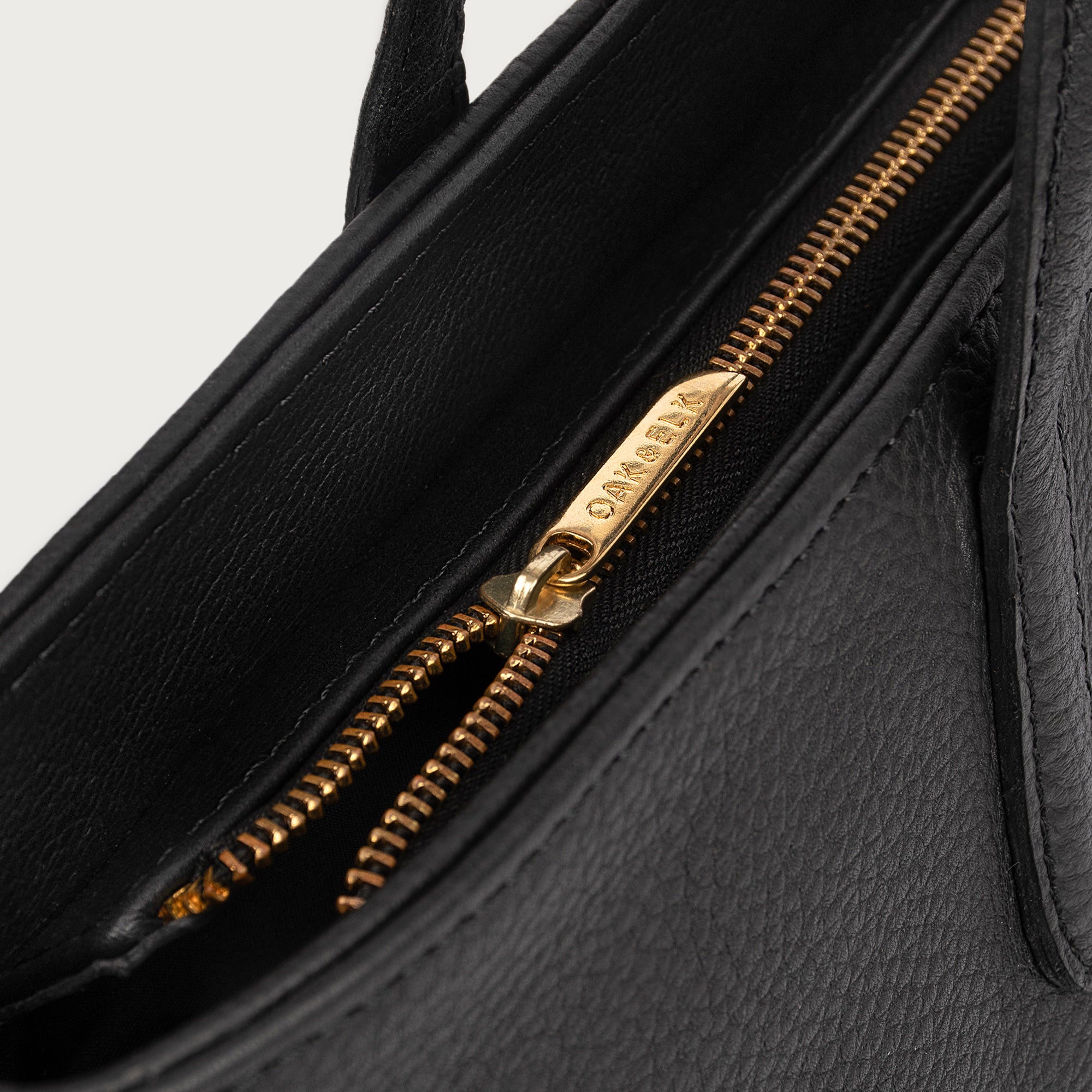 Leather tote made from top-grain leather, featuring smooth golden zipper, inner pouch, and structured design for daily use.