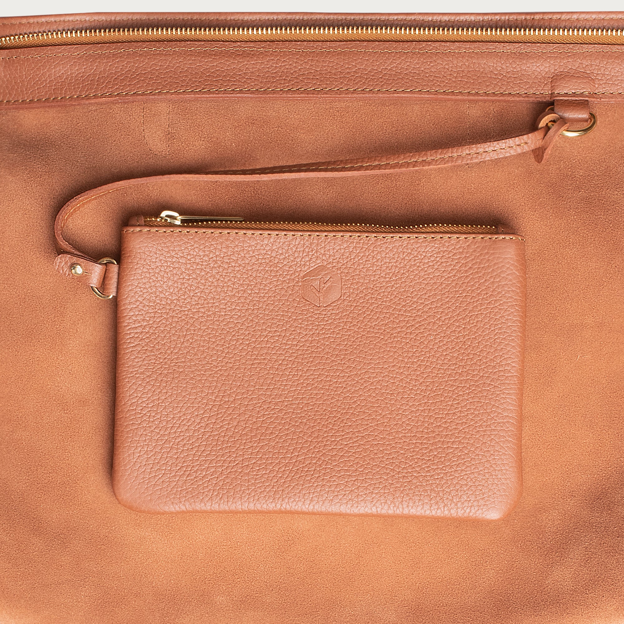 Leather tote made from top-grain leather, featuring smooth golden zipper, inner pouch, and structured design for daily use.