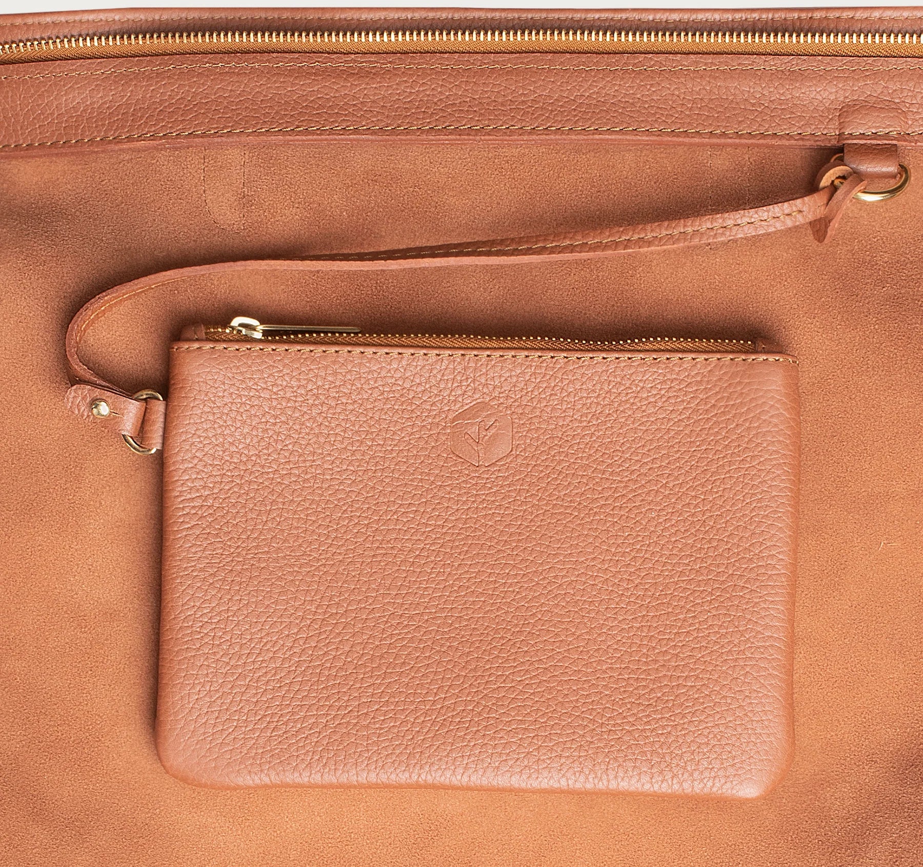 Leather tote made from top-grain leather, featuring smooth golden zipper, inner pouch, and structured design for daily use.