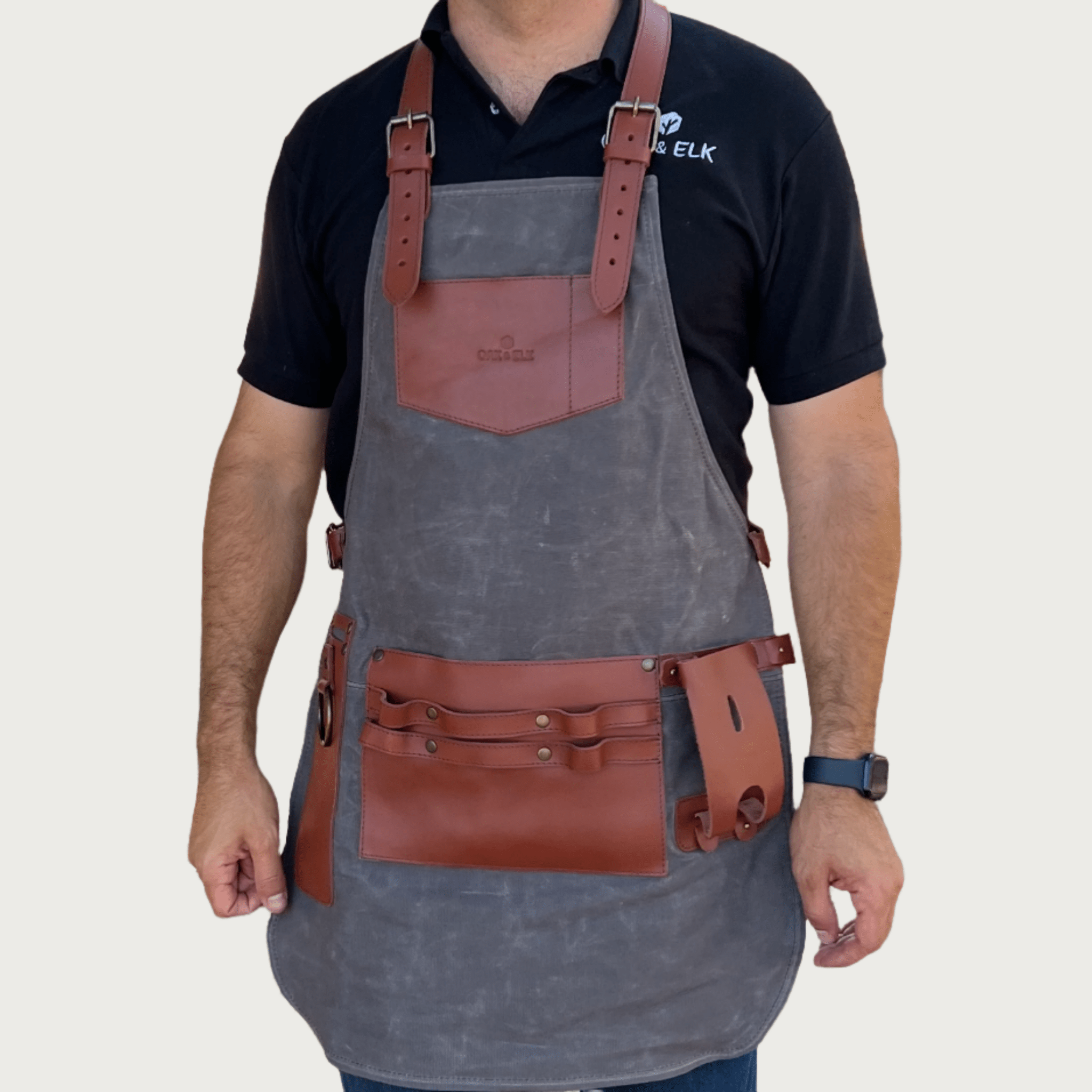 Gray canvas and leather apron for pottery, front view with bib coverage and leather tool pockets