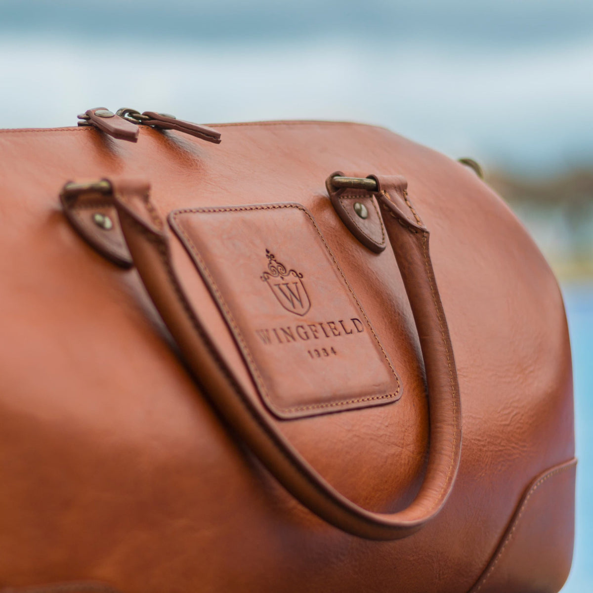 Tan vegetable-tanned small leather duffel bag, a durable choice in the leather carbon footprint debate