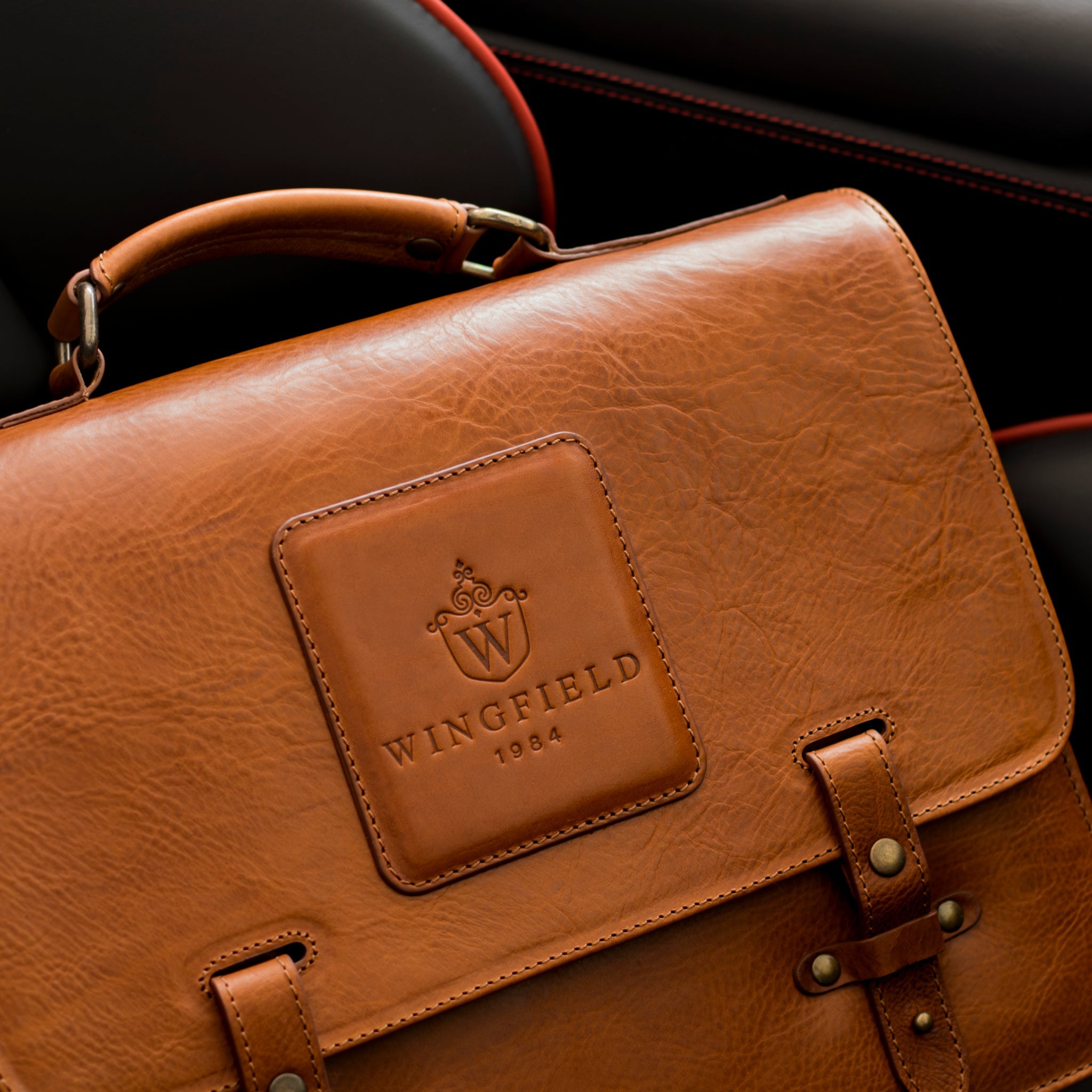 Close-up of stitching and brass hardware showing how to tell if a leather bag is well made