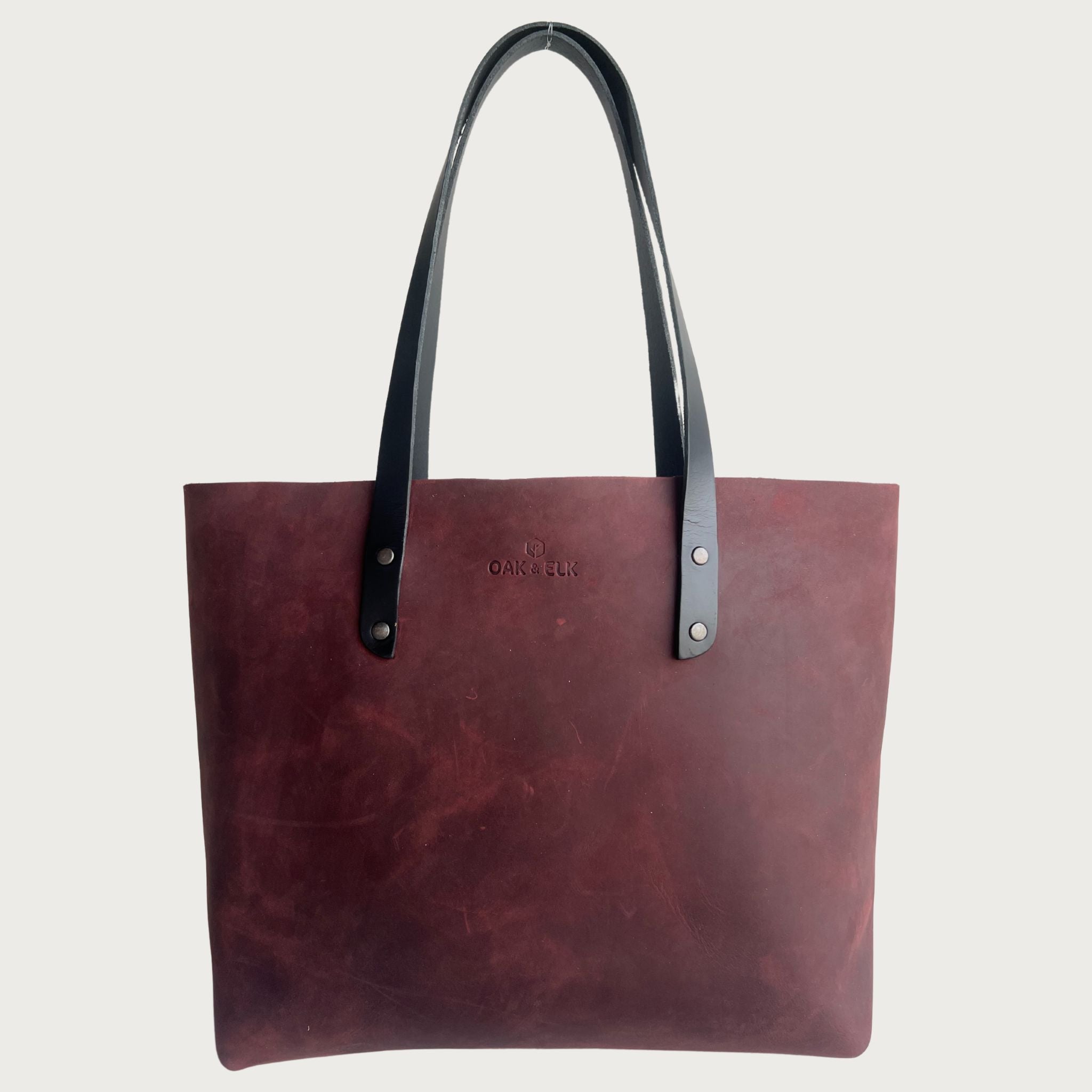 Burgundy full-grain Classic Leather Tote by OAK & ELK, shown alongside a discussion of bio-based leather alternatives