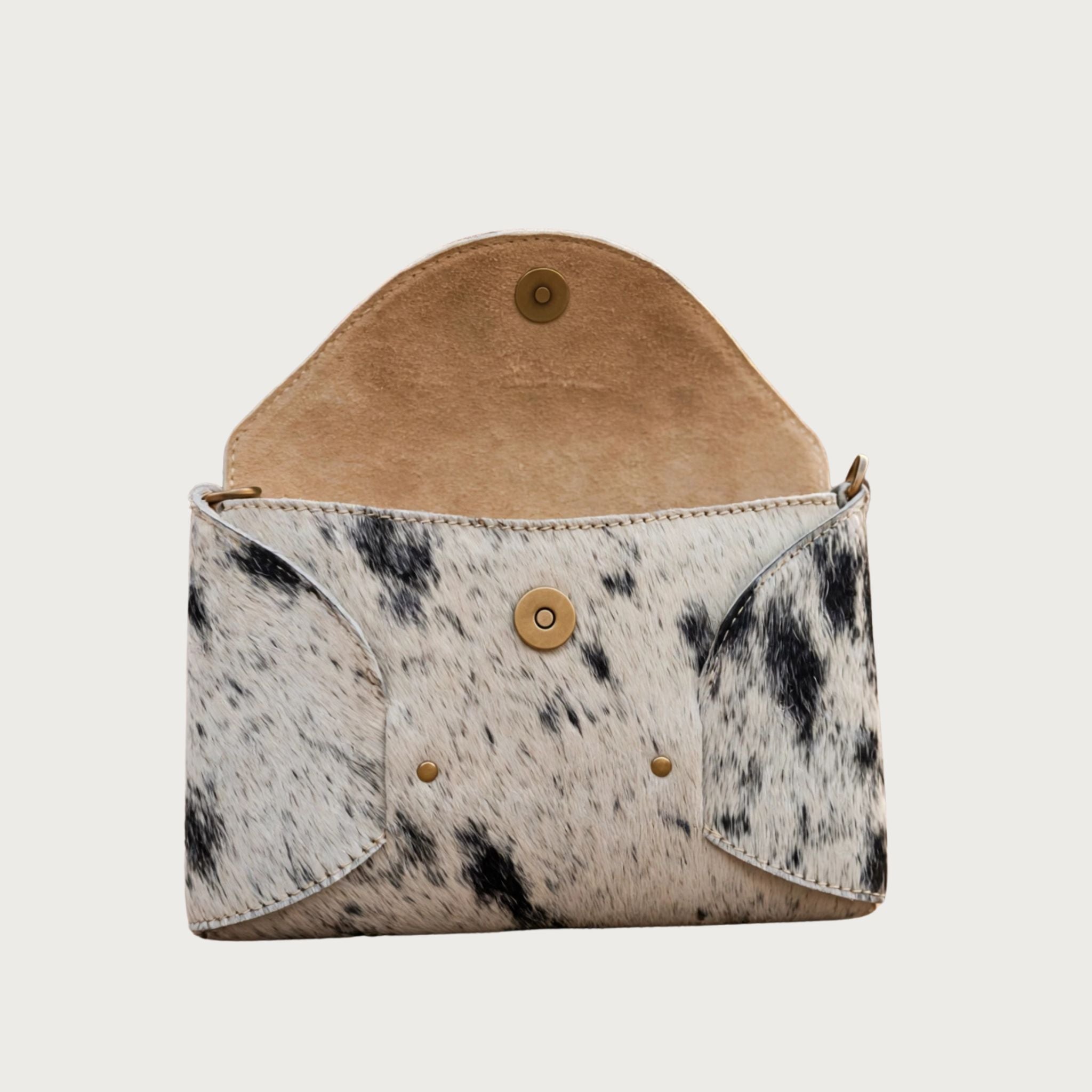 Oak & Elk PALOMA cowhide crossbody bag open on white background showing natural tan suede interior and antique brass magnetic snap