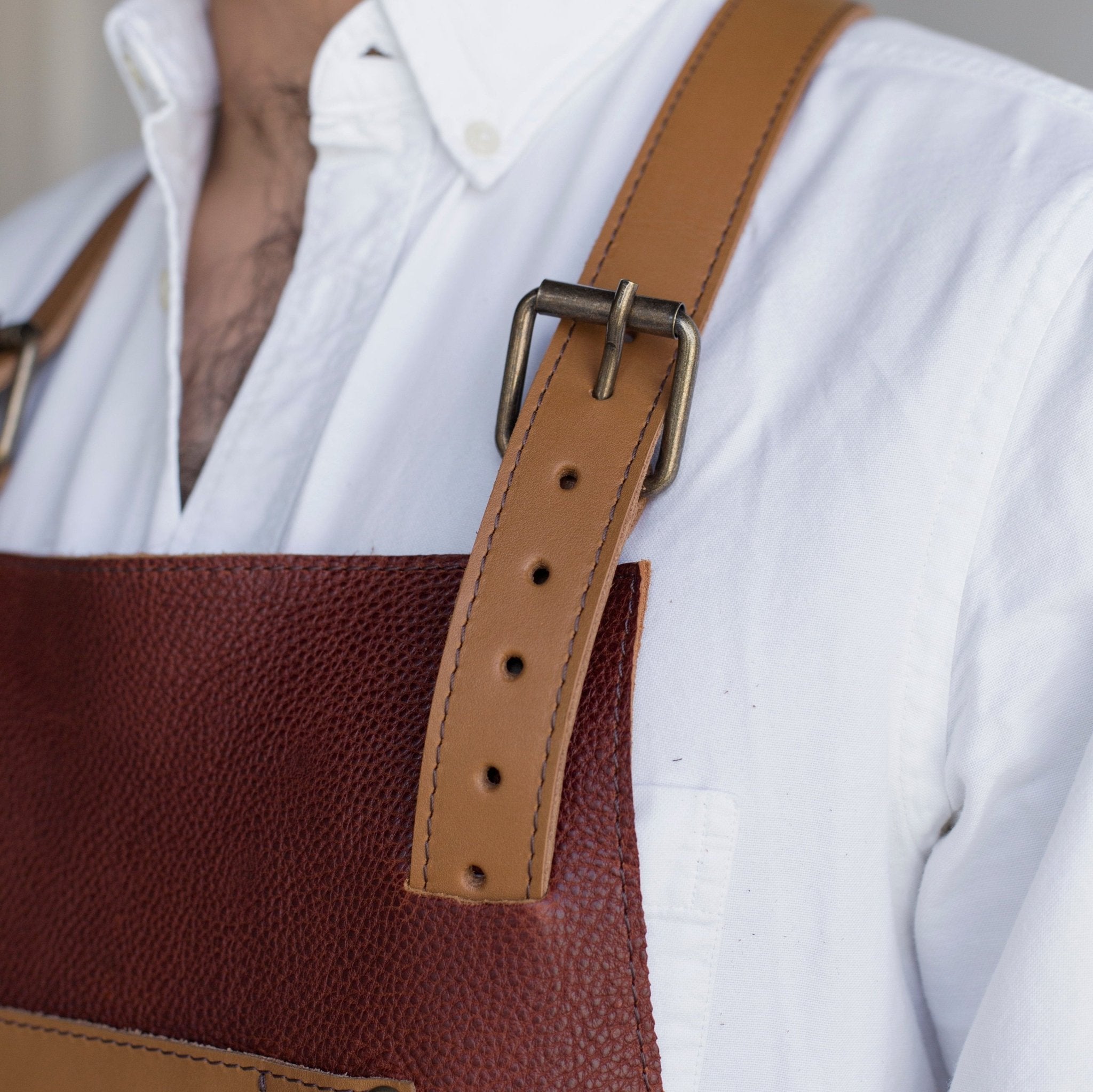 Full leather apron, adjustable straps, front chest pocket, tool loops, and rich texture, ideal for grilling, crafts, shop use
